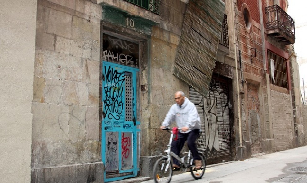 Un home en bicicleta davant del número 10 del carrer Arc del Teatre 