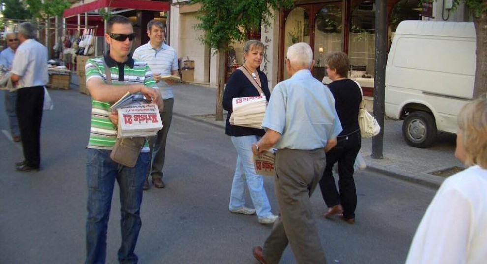 Josep Maria Gili repartint exemplars fets pel partit, el 2009