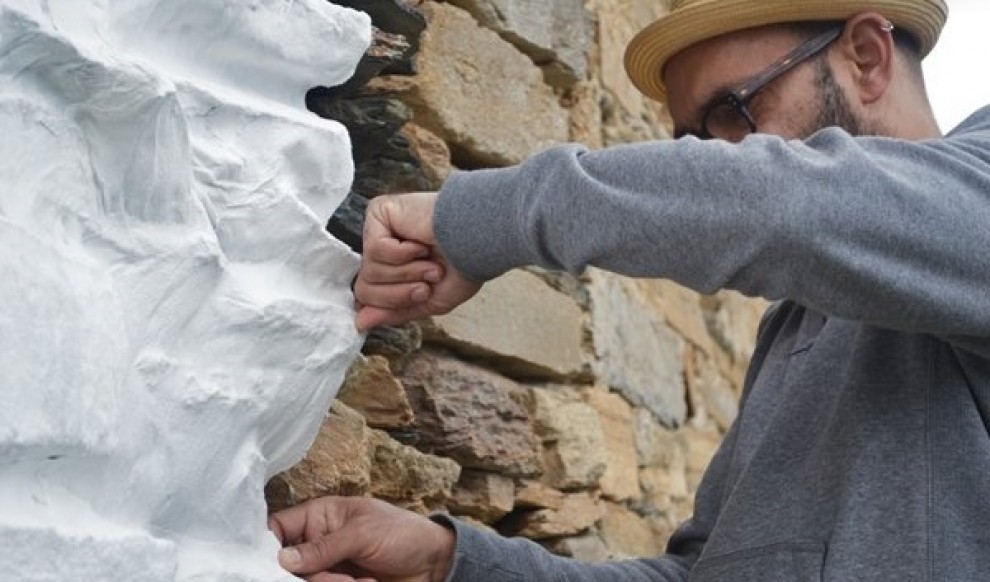 L'artista Dario Zeruto folra de paper una paret a l'ermita de Santa Maria de la Serra