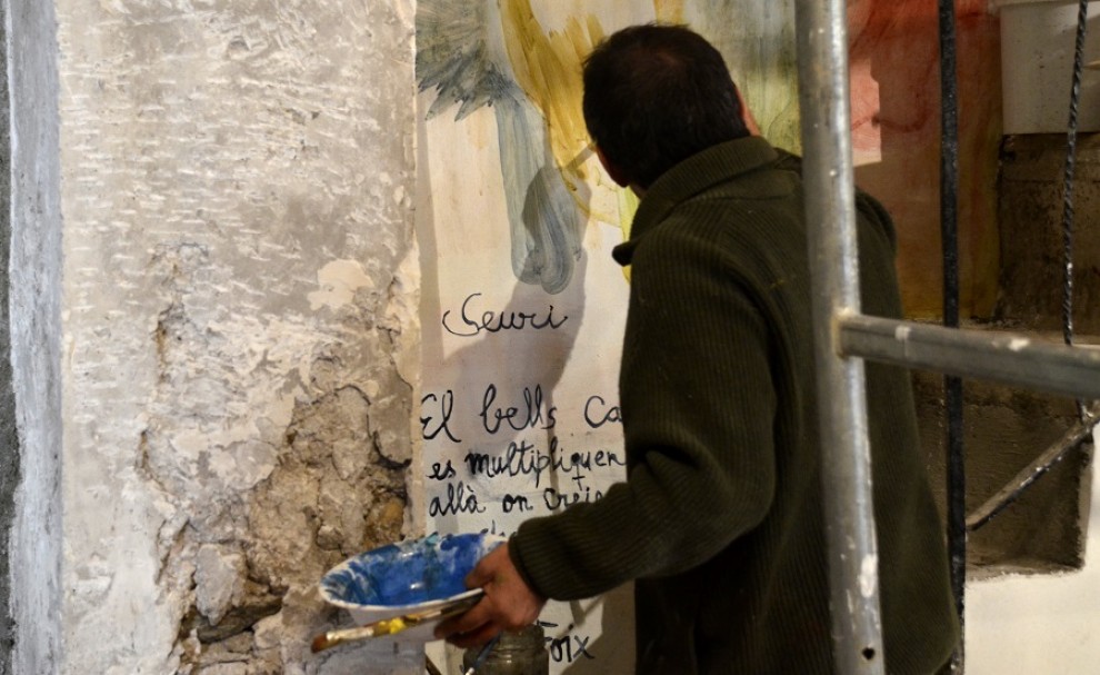 Santi Moix pintant a un dels laterals de l'església de Saurí