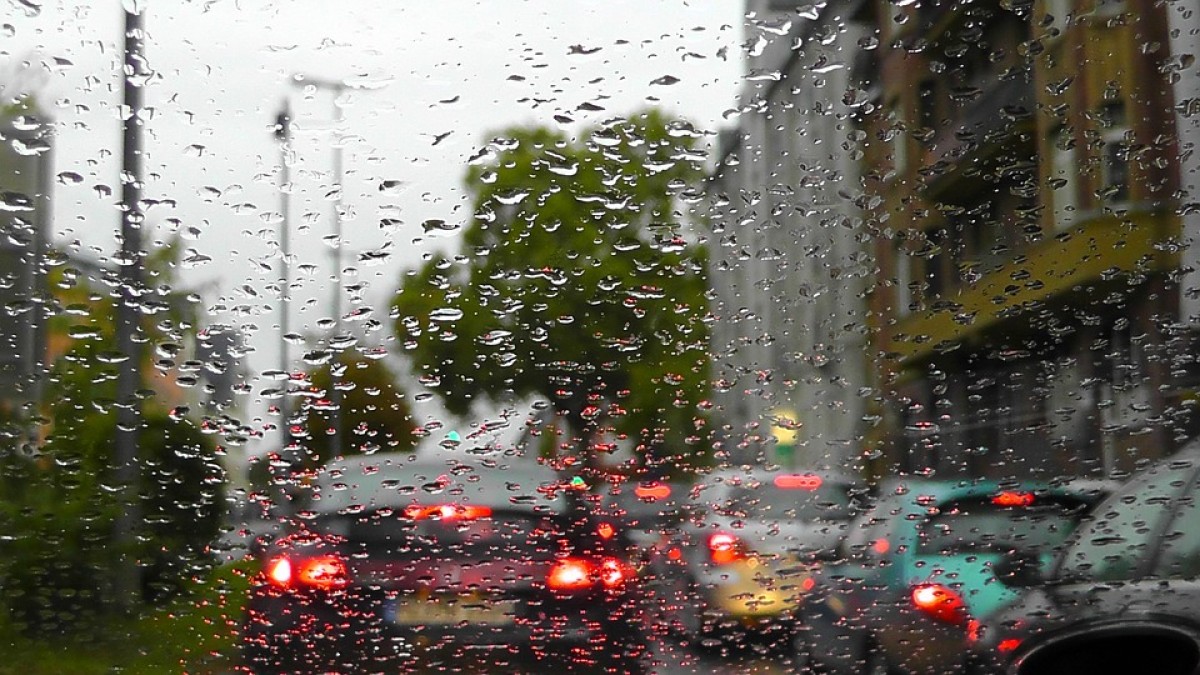 Cua de cotxes en una ciutat, mentre plou