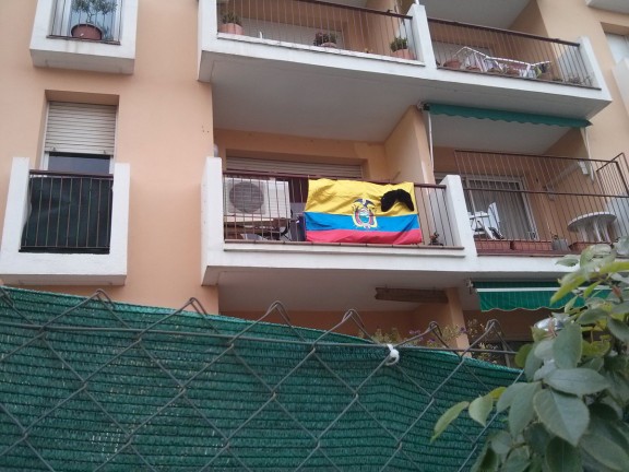 Bandera de l'Equador amb llacet negre en un balcó de Sant Celoni.