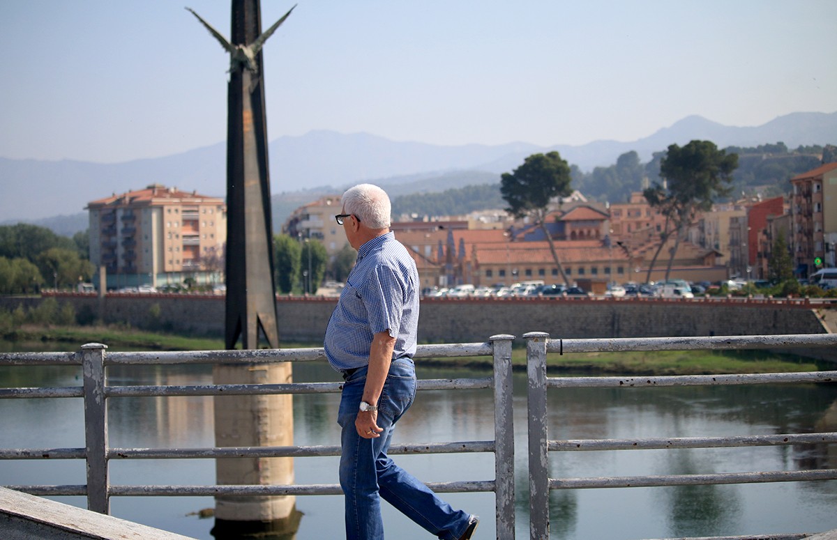 Un ciutadà camina pel pont de l'Estat mentre observa el monument. 