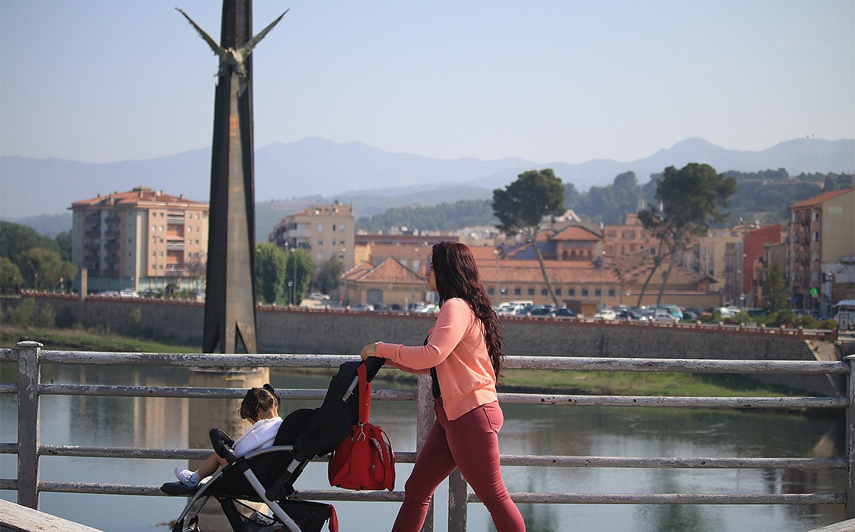 Una dona i una nena passejant per davant del monument franquista