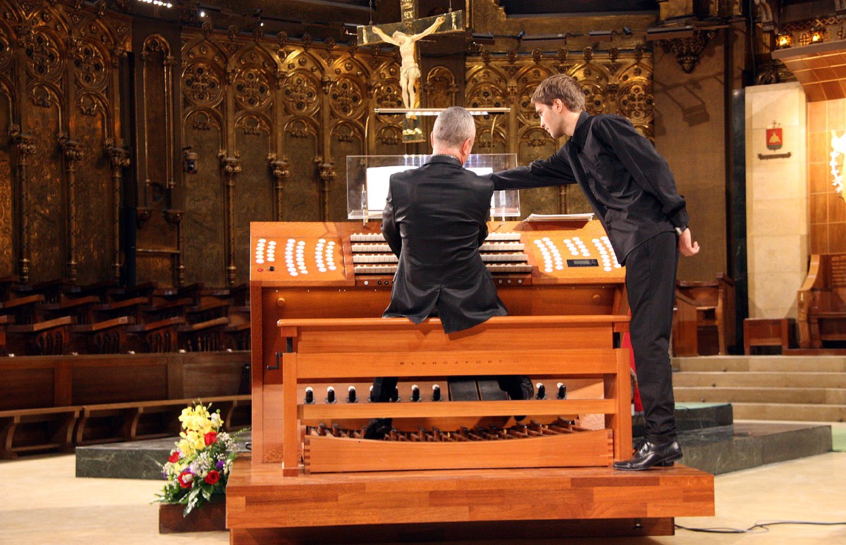 L'organista Olivier Vernet, d'esquenes, tocant la consola de l'orgue de Montserrat en una imatge de 2016