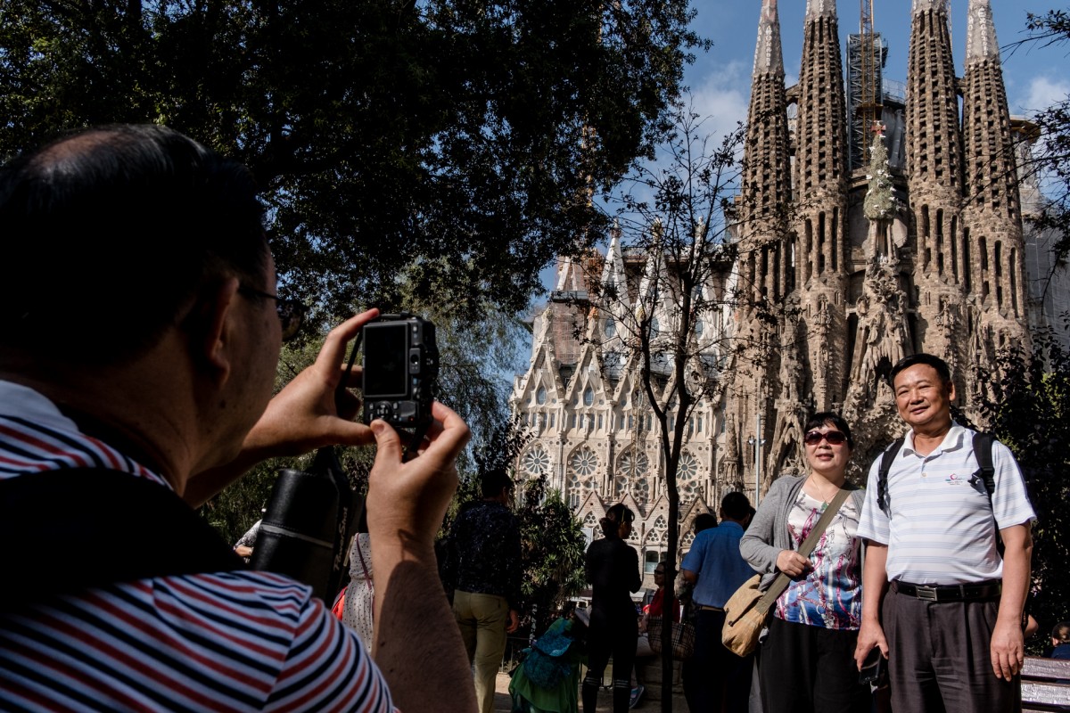 Uns turistes es fotografien davant la Sagrada Familia.