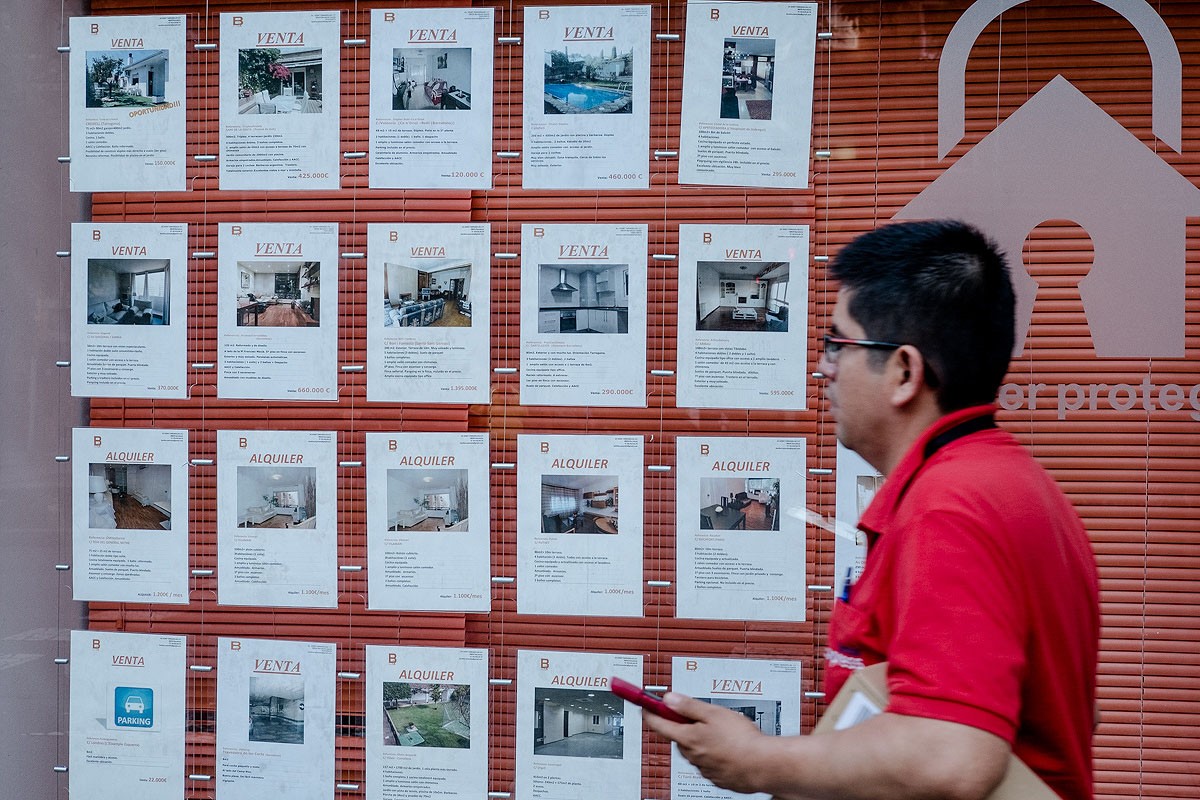 Anuncis de venda i lloguer d'habitatges a l'aparador d'una immobiliària de Barcelona