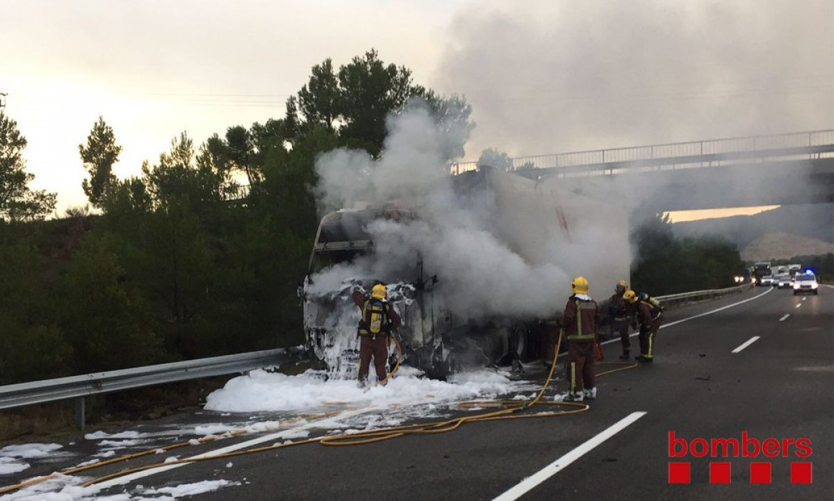 Els Bombers treballant per sufocar les flames del camió que s'ha incendiat a l'AP-7 