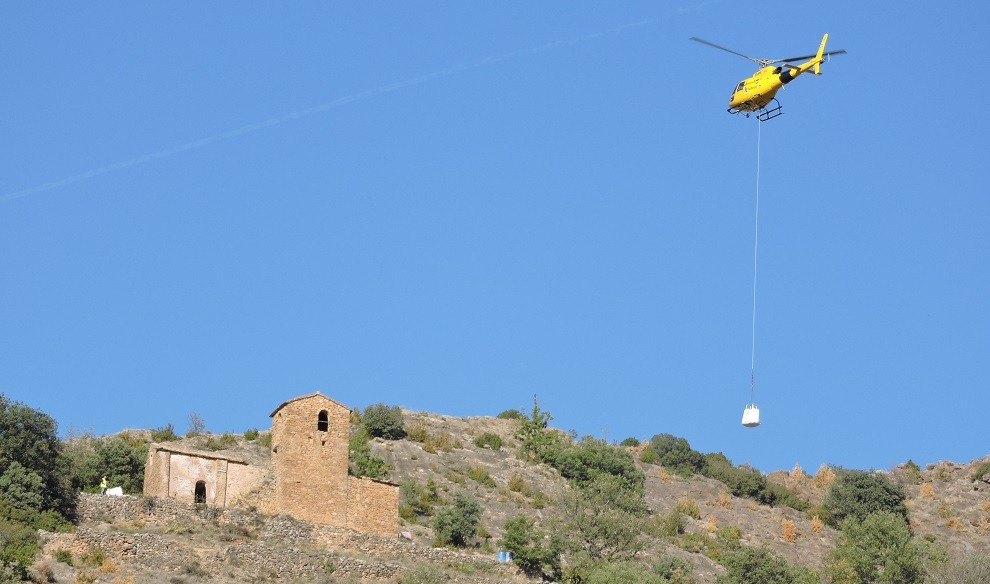 L'helicòpter transportant el material per iniciar les obres