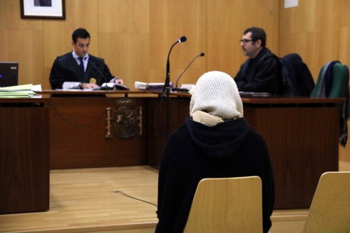 L'acusada, d'esquena a càmera, escolta la lectura de la sentència al jutjat penal de Figueres
