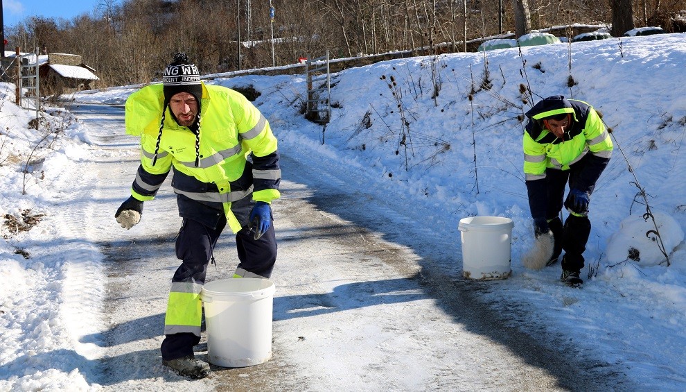 Dos operaris tirant sal pels carrers del nucli de Sort, aquest dimecres