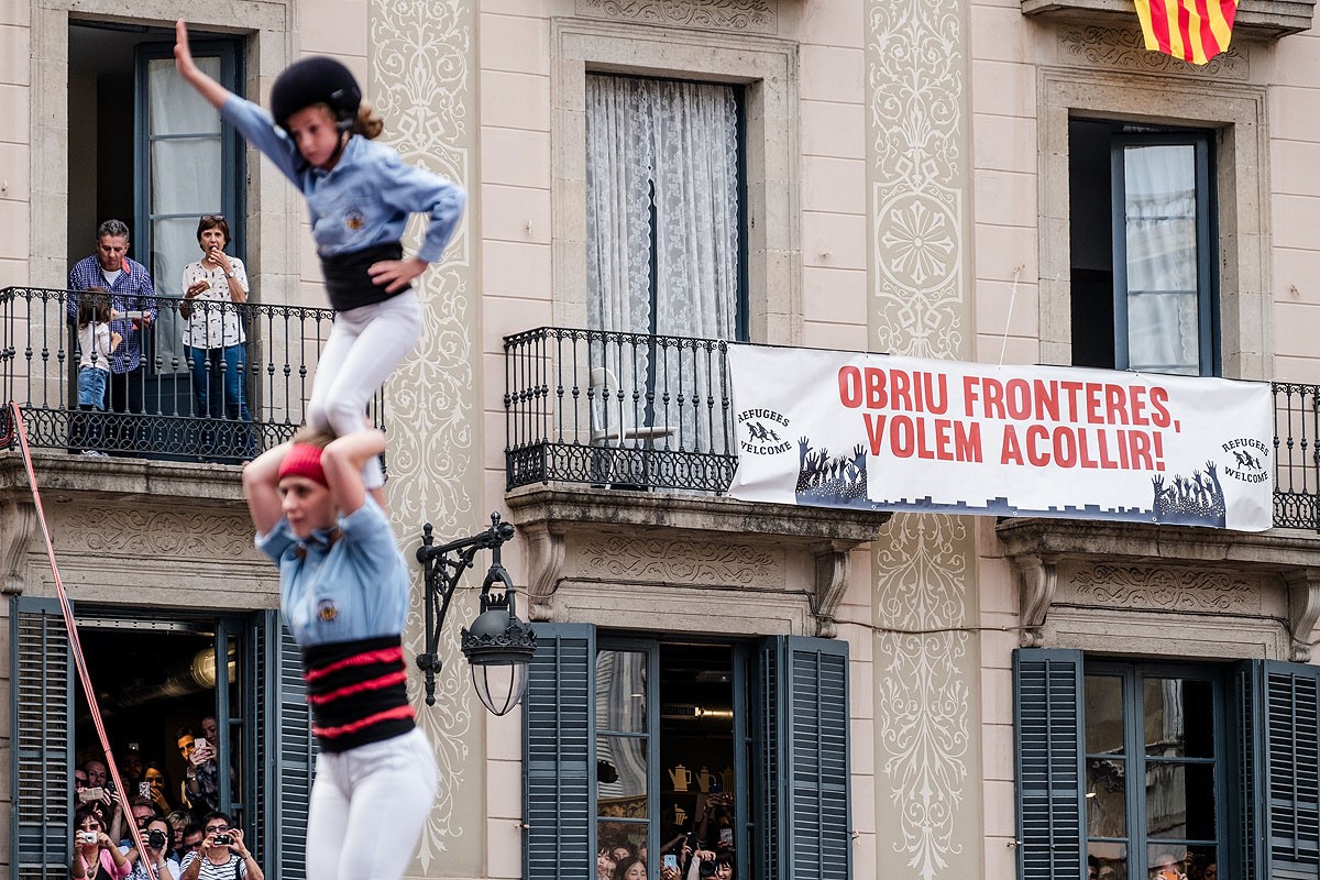 Pancarta a favor de l'acollida de refugiats, en un balcó de de la plaça Sant Jaume
