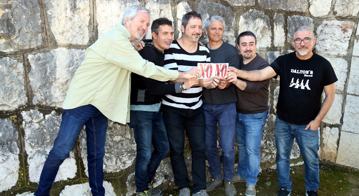 Els sis membres del grup Quico el Cèlio, el Noi i el Mut de Ferreries aguantant dos exemplars dels seu nou disc, sota el Pont del Vicari de Roquetes.