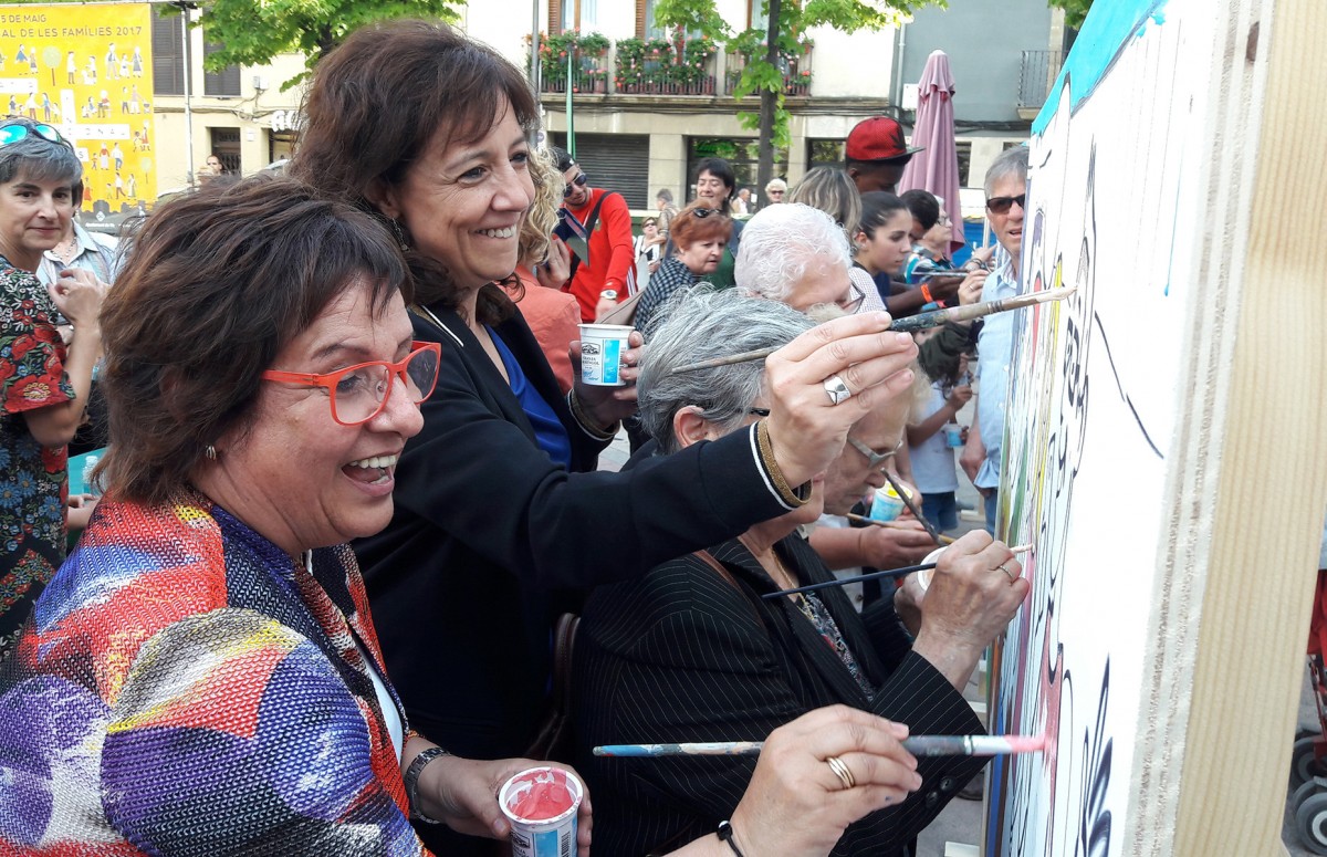 L'alcaldessa de Vic i la consellera pintant el mural