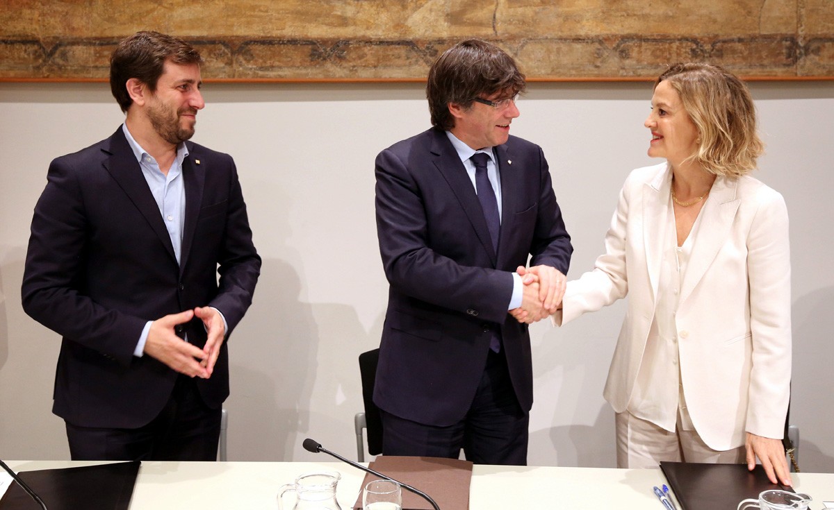 El president Puigdemont encaixant la mà amb la vicepresidenta primera de la Fundació Amancio Ortega, Flora Pérez