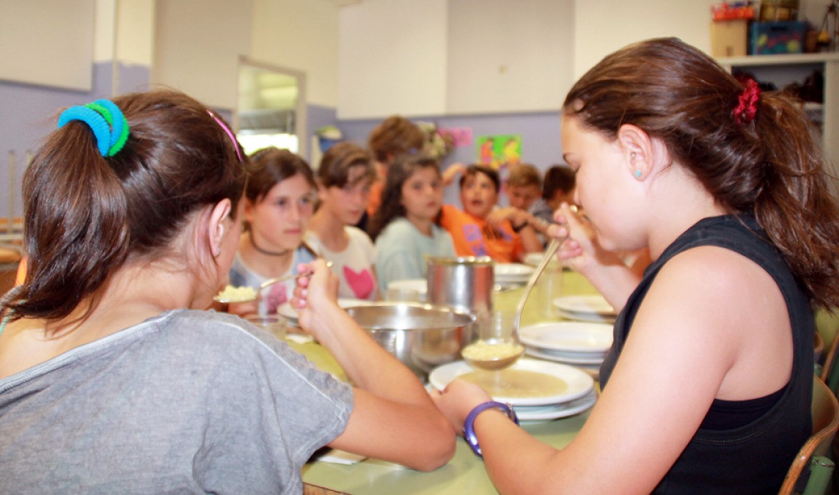 Nois i noies a l'hora de dinar al menjador de l'escola d'Avià