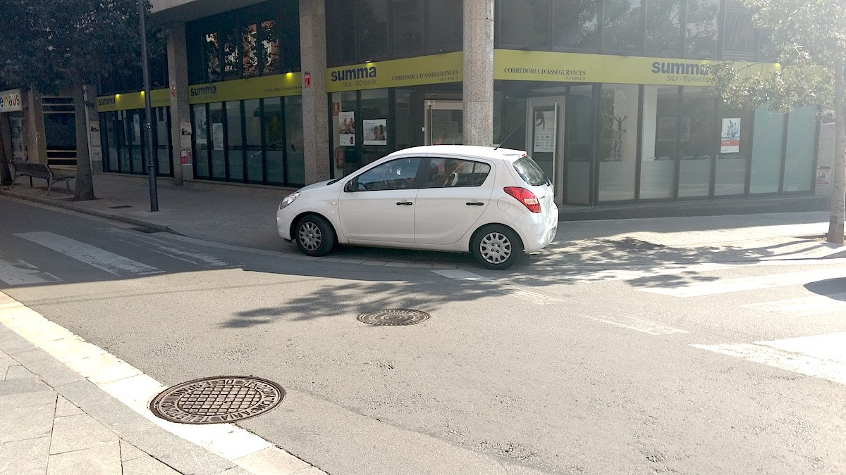 Un cotxe aparcat sobre la vorera