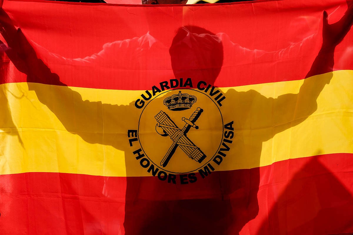 La Guardia Civil es percep com un element identificatiu d'espanyolitat. A la imatge, un manifestant exhibeix una bandera espanyola en què hi ha estampat l'escut del cos en una concentració de protesta davant de Catalunya Ràdio.