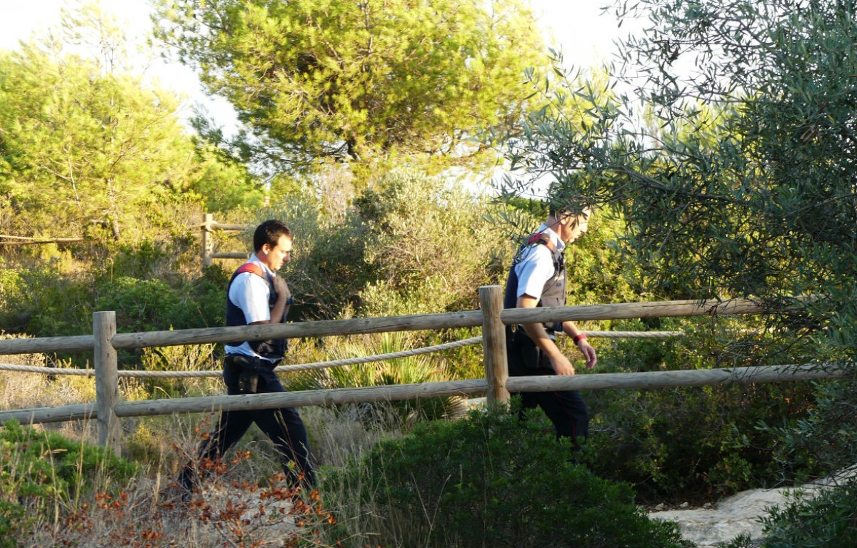 Dos agents dels Mossos dirigint-se al lloc on s'ha trobat el cos de la dona 
