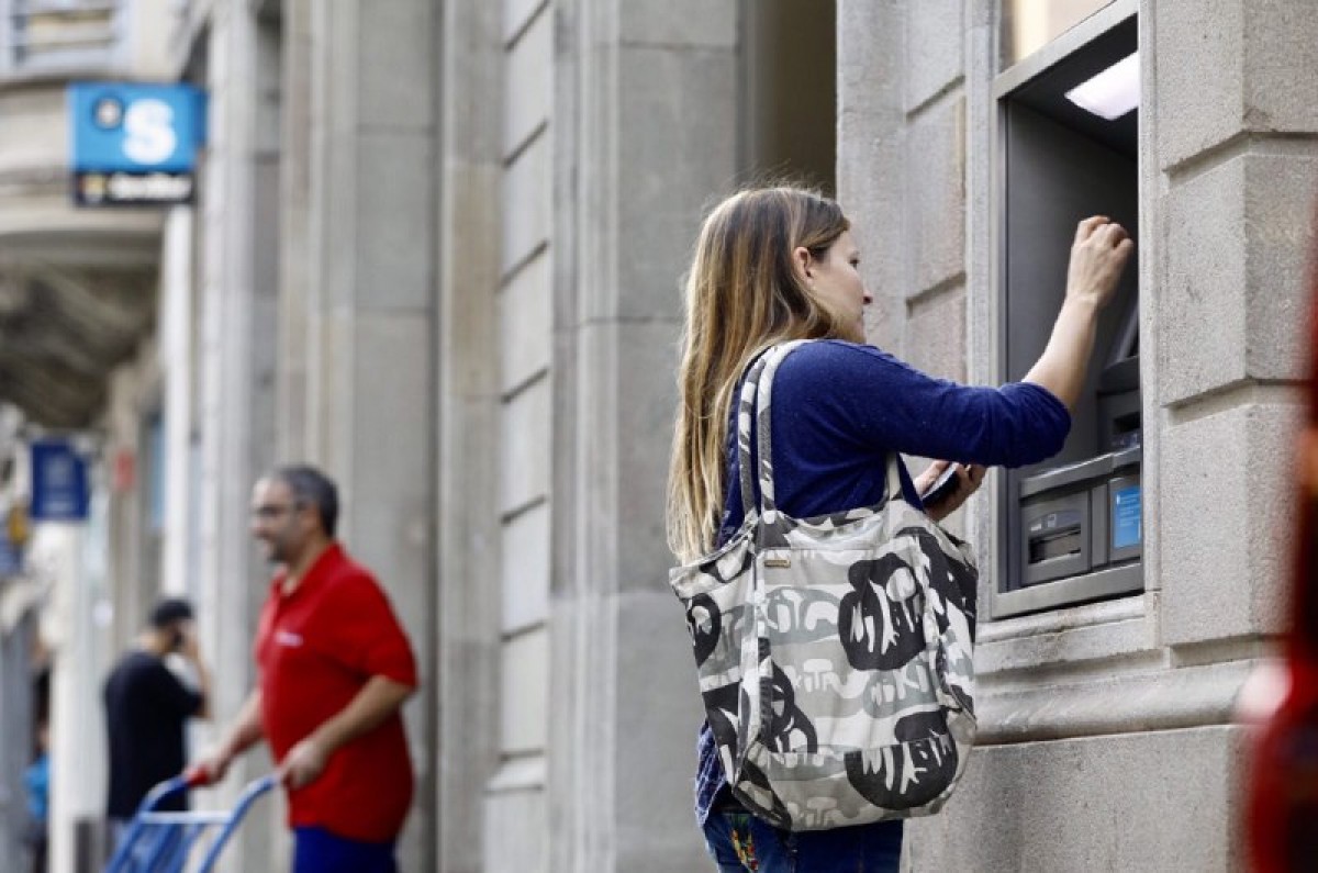 Una noia retirant diners d'un caixer del centre de Sabadell 