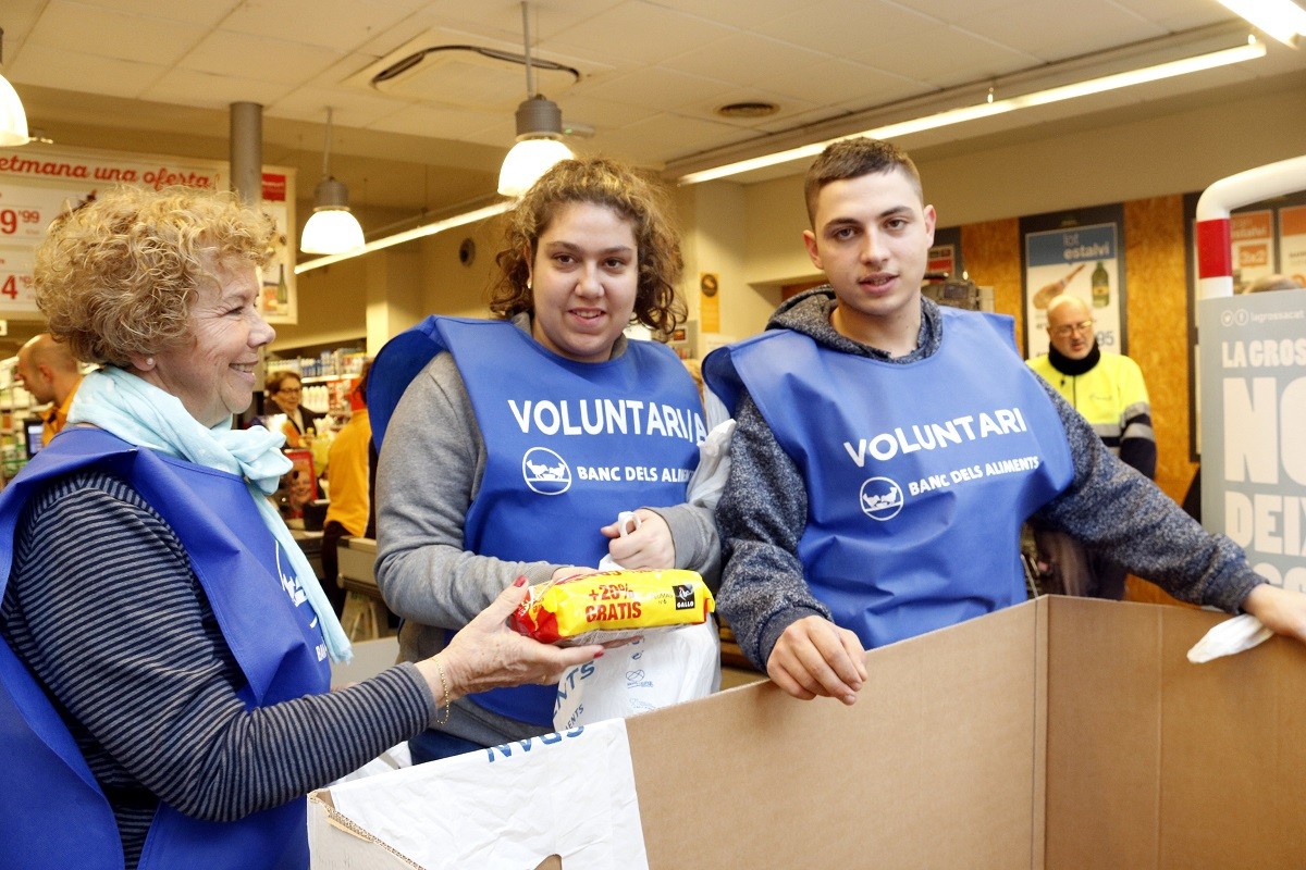 Tres voluntaris del Gran Recapte en un supermercat del Mercat de la Marina de Barcelona.