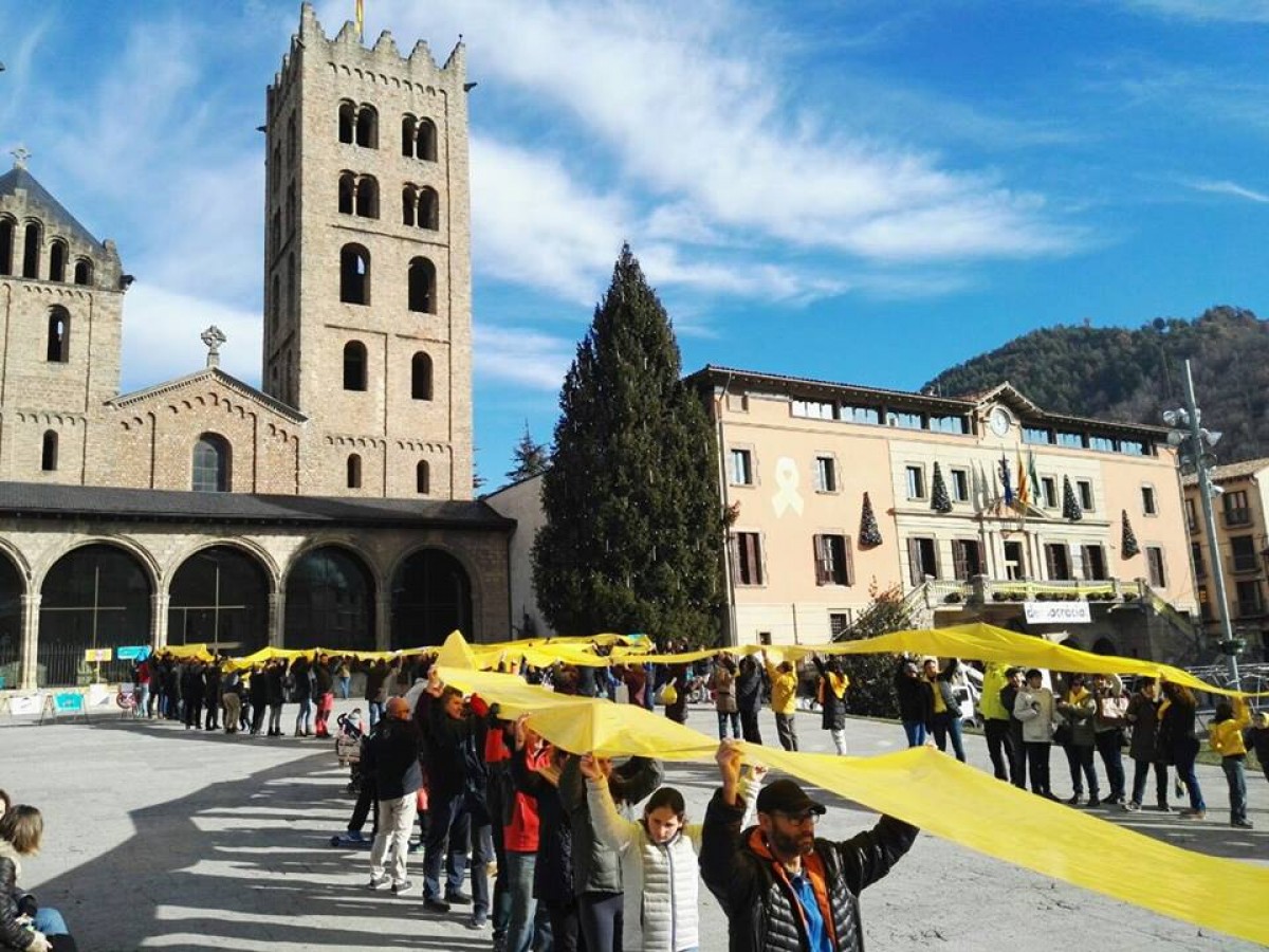 Unes 250 persones han desplegat un llaç groc gegant en solidaritat amb els presos a la plaça del Monestir