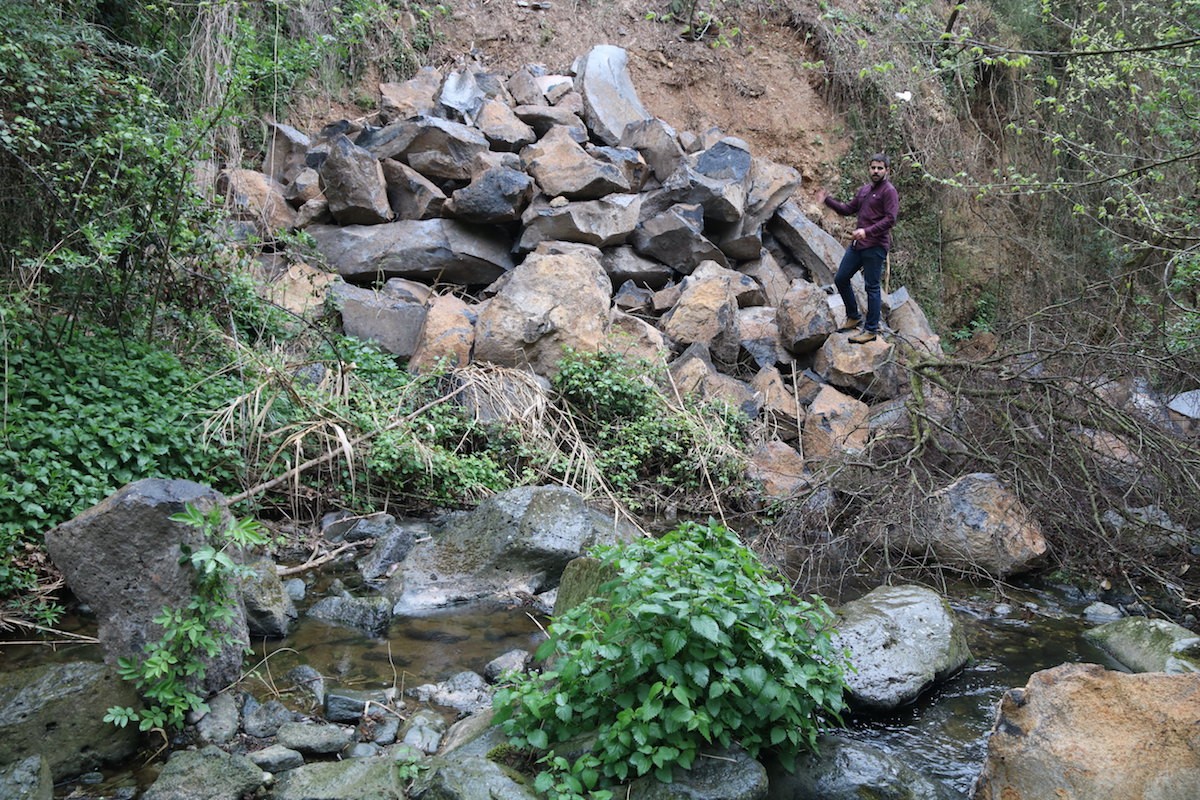 Les pedres acumulades arran de l'esllavissada de març de 2017 a la cinglera de Castellfollit de la Roca, amb el regidor de Medi Ambient, Roger Santaló..