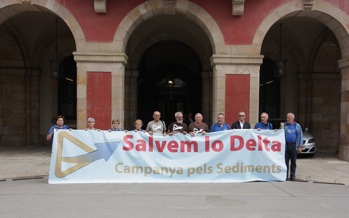 Membres de la Campanya pels Sediments a les portes del Parlament de Catalunya amb una pancarta que diu 