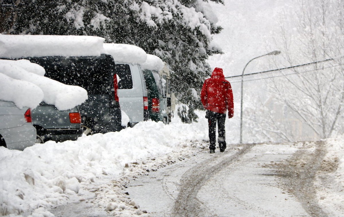 Un veí d’Esterri d’Àneu passejant pels carrers de la població sota la intensa nevada d’aquest matí