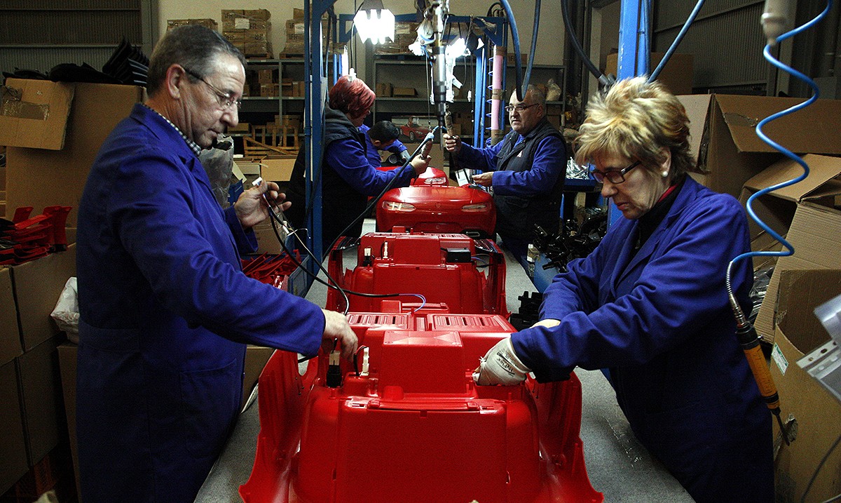Treballadors d'una fàbrica de joguines a Ibi en el procés de fabricació d'un cotxet infantil.