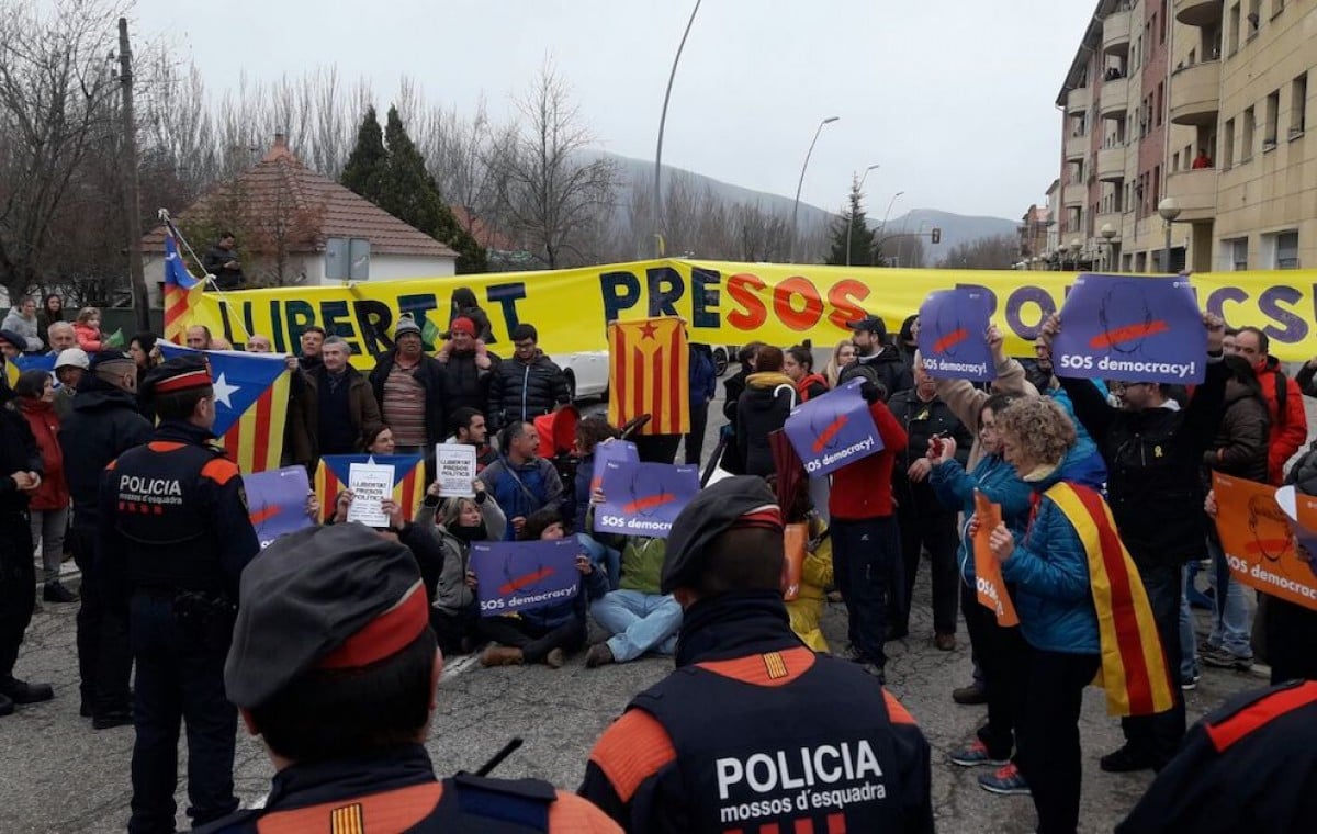 Els manifestants durant l’asseguda sota la mirada dels Mossos