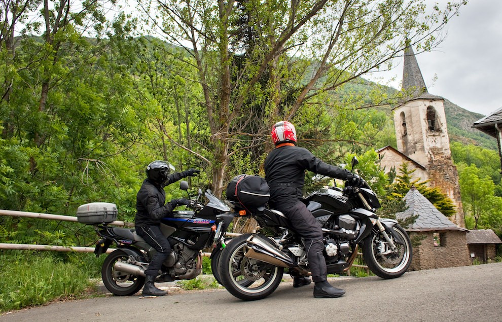 Dos motoristes davant una ermita del Pallars Sobirà
