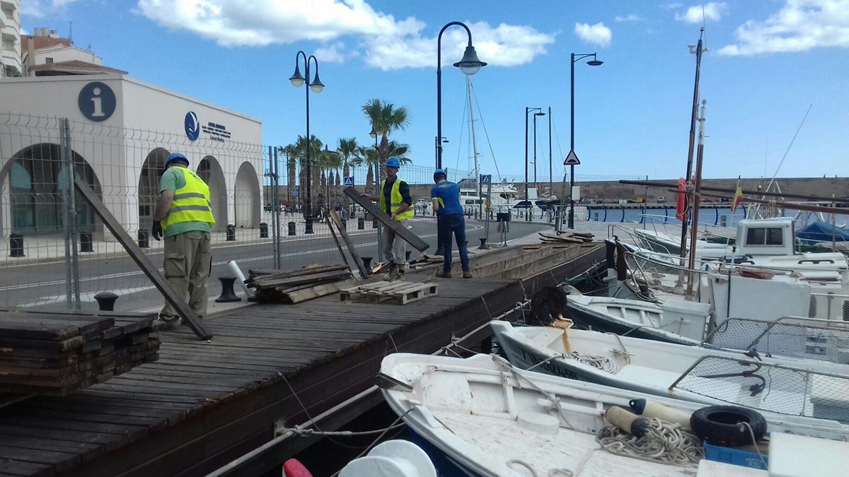 Desmuntatge d'un tram de passarel·la de fusta al port de l'Ametlla de Mar.