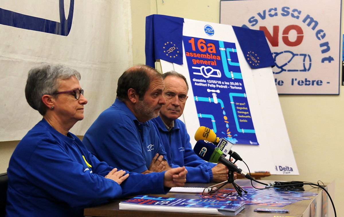 Els portaveus de la PDE Matilde Font, Joan Antoni Panisello i Manolo Tomàs, amb el cartell de la 16a assemblea general de l'entitat, al fons
