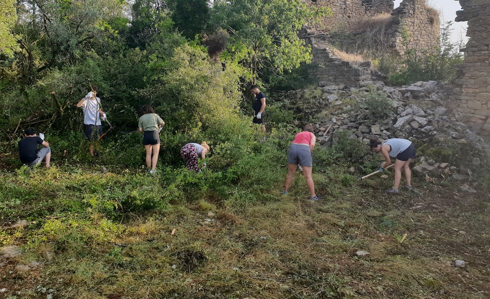 Els joves del camp de treball netejant el voltant de l'ermita de Sant Cebrià