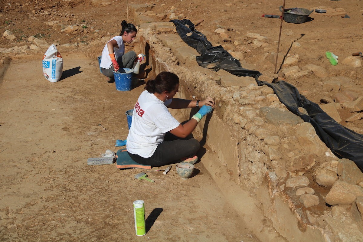 Dues restauradores treballen al jaciment de Can Ring de Besalú.