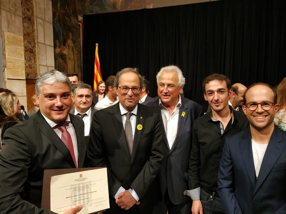 Alguns dels placers del Mercat d'OLot, junt amb el president Quim Torra i el batlle, Josep M. Corominas, llueixen el guardó atorgat.