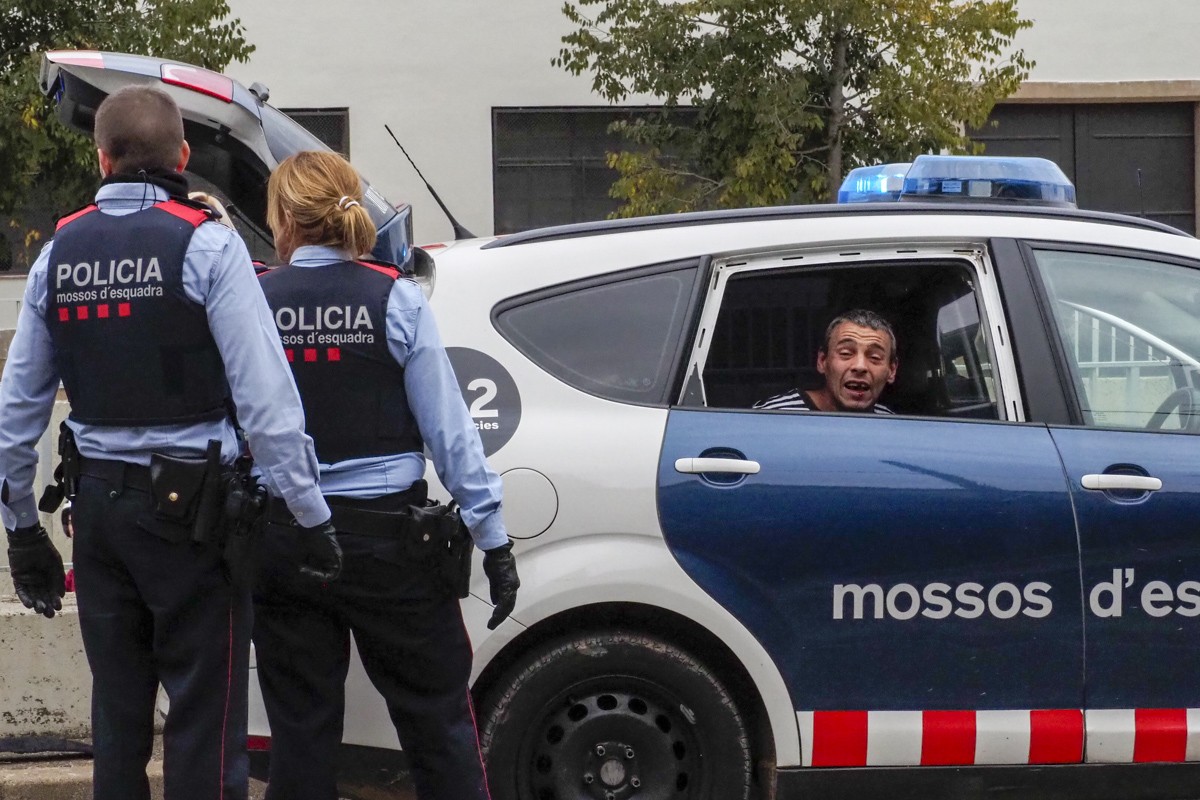 L'home detingut, dins del vehicle de Mossos sense el vidre.