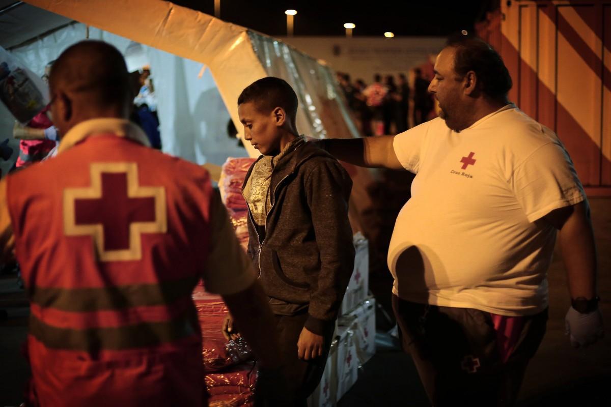 Un jove és atès per la Creu Roja, al port d'Algesiras.