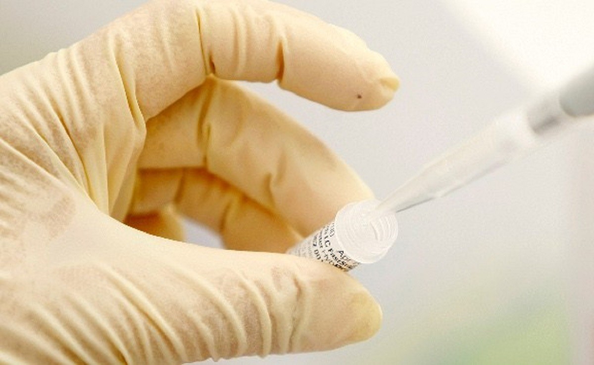 Un investigador pren la dosi d'un medicament en un laboratori.