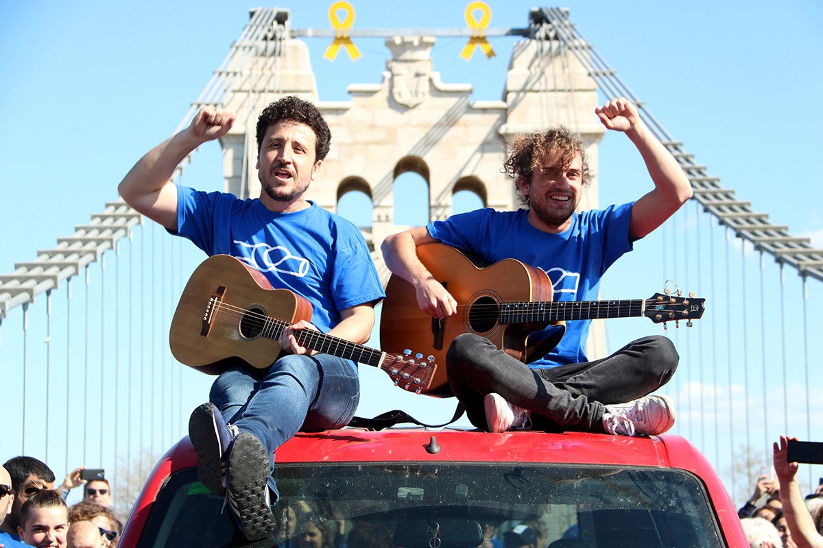 El cantant de Pepet i Marieta, Josep Bordes, i un membre del grup damunt d'un vehicle durant el rodatge del videoclip 'La força de l'Ebre', al Pont d'Amposta
