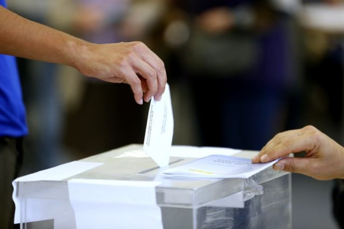 Un votant dipositant el sobre en una urna