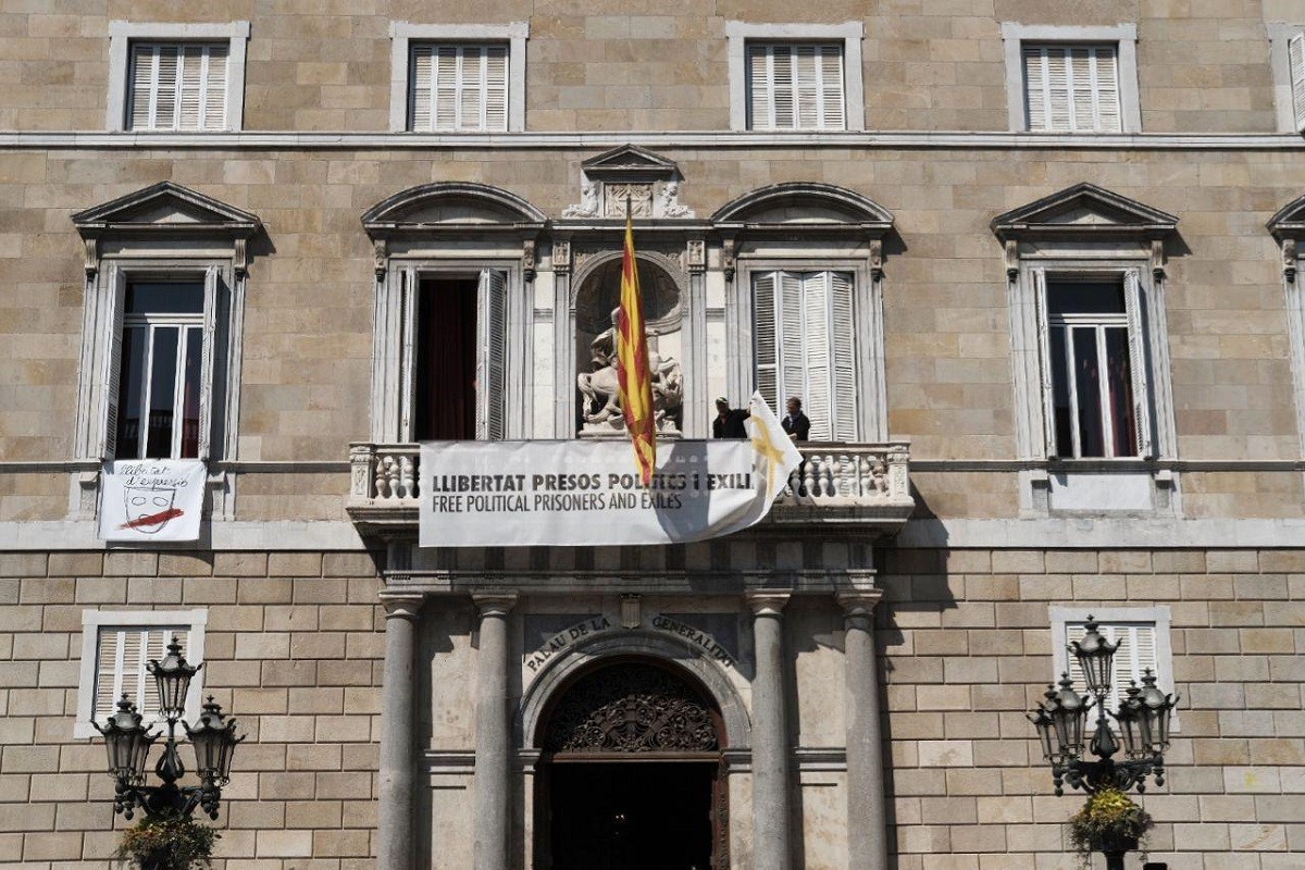 Funcionaris de la Generalitat retirant les pancartes amb els llaços del Palau.