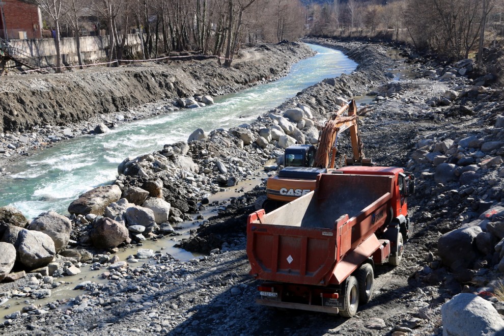 Una màquina i un camió treballant al riu Noguera Pallaresa, al seu pas per Sort