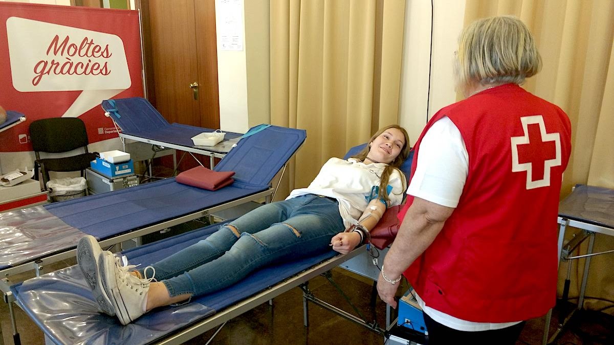 Una noia donant sang en una campanya de la Creu Roja.