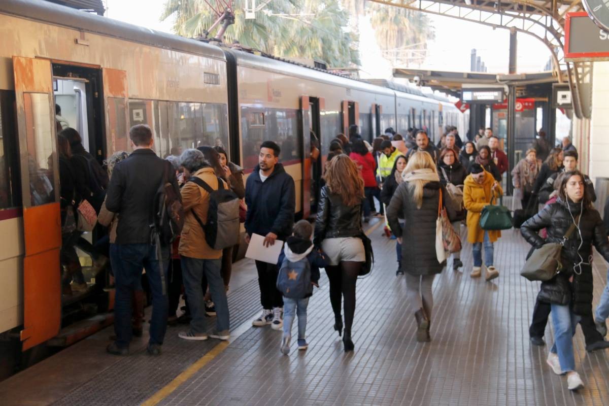 Viatgers baixant i pujant a un tren de Rodalies, a l'estació de Mataró.