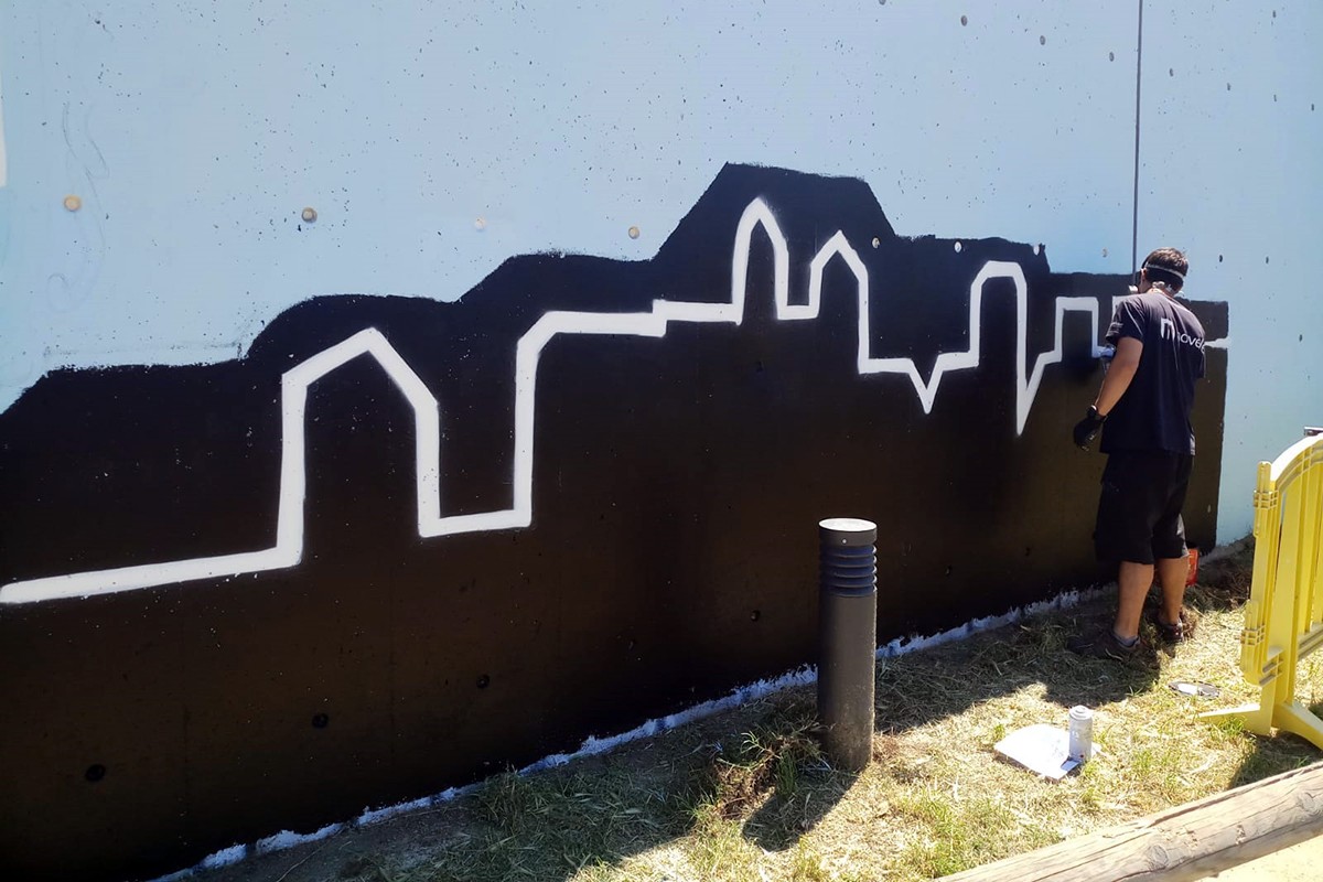 Eneko Ruz pintant el mur que es troba davant dels horts de La Sagrera