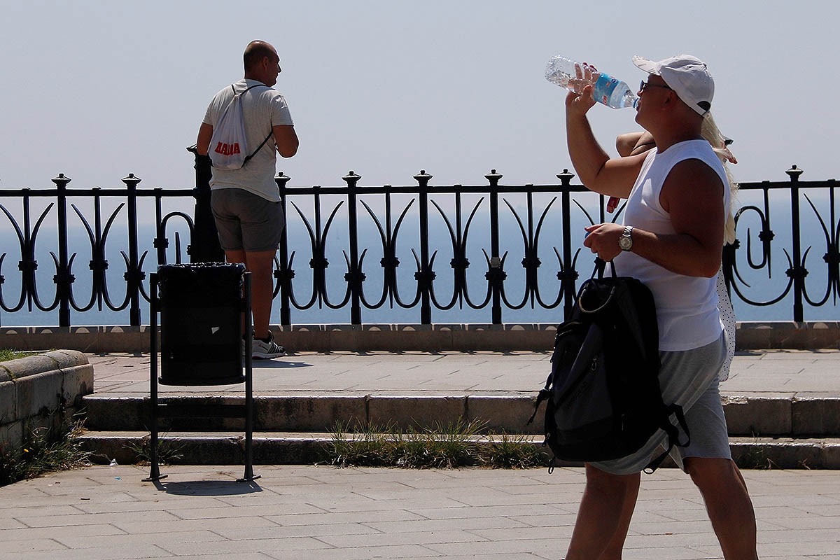 Un home bevent aigua mentre passeja al Balcó del Mediterrani de Tarragona