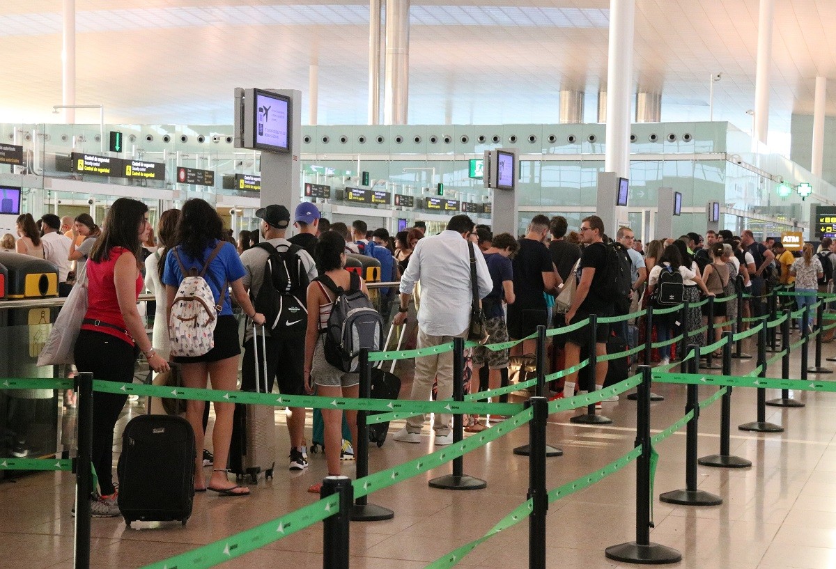 Cues de passatgers al control de seguretat de l'aeroport del Prat