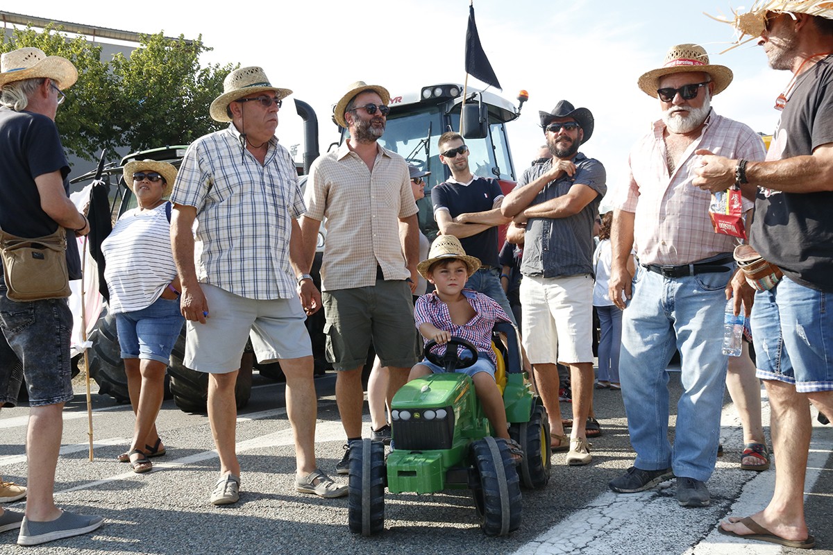 Un grup de pagesos amb tractors en el tall d'este diumenge 11 d'agost a Flix